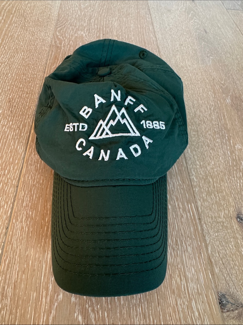 Lago Apparel Co. Banff, Canada Embroidered Dark Green Adult Baseball Cap.